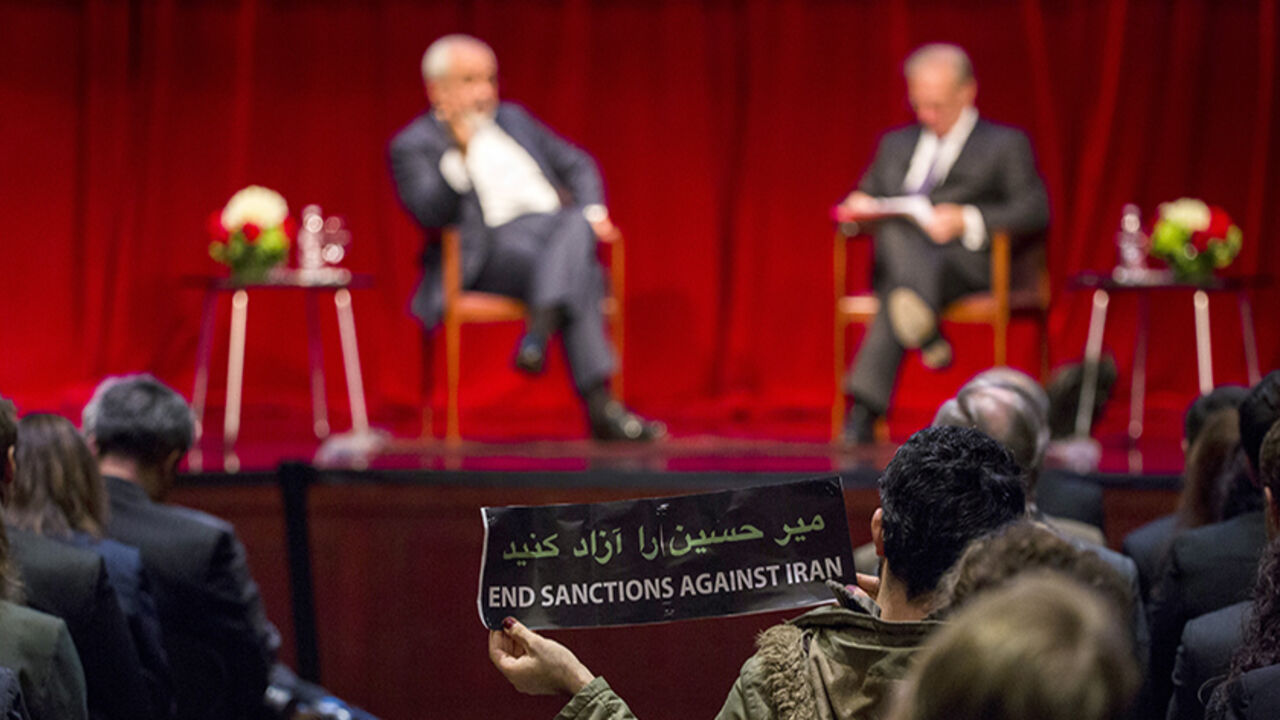IRAN-NUCLEAR/ZARIF A demonstrator holds up a sign while Iranian Foreign Minister Mohammad Javad Zarif speaks with Washington Post journalist David Ignatius at the New York University (NYU) Center on International Cooperation in New York April 29, 2015. Iran's foreign minister on Wednesday offered assurances that Tehran is committed to maintaining freedom of navigation in the Persian Gulf in the aftermath of the seizure of a commercial ship by Iranian forces a day earlier. REUTERS/Lucas Jackson - RTX1AUZQ