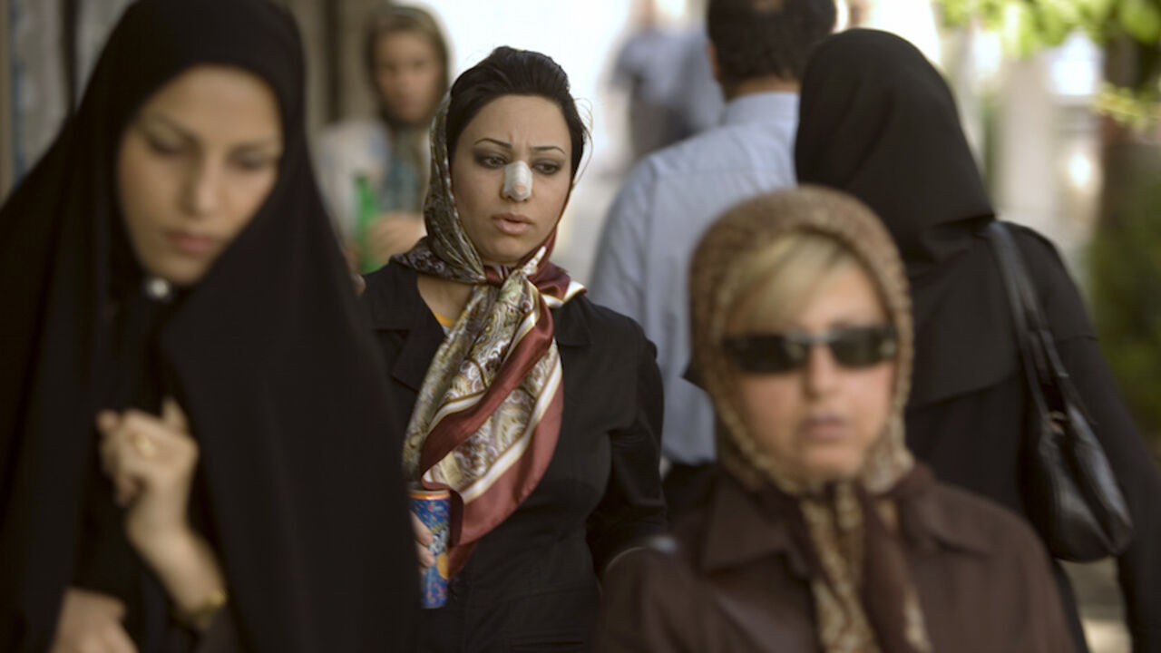 IRAN/ Arezoo Abassi (C) walks along a street in Tehran June 24, 2007, three weeks after undergoing nose surgery. REUTERS/Caren Firouz (IRAN) - RTR1R44J