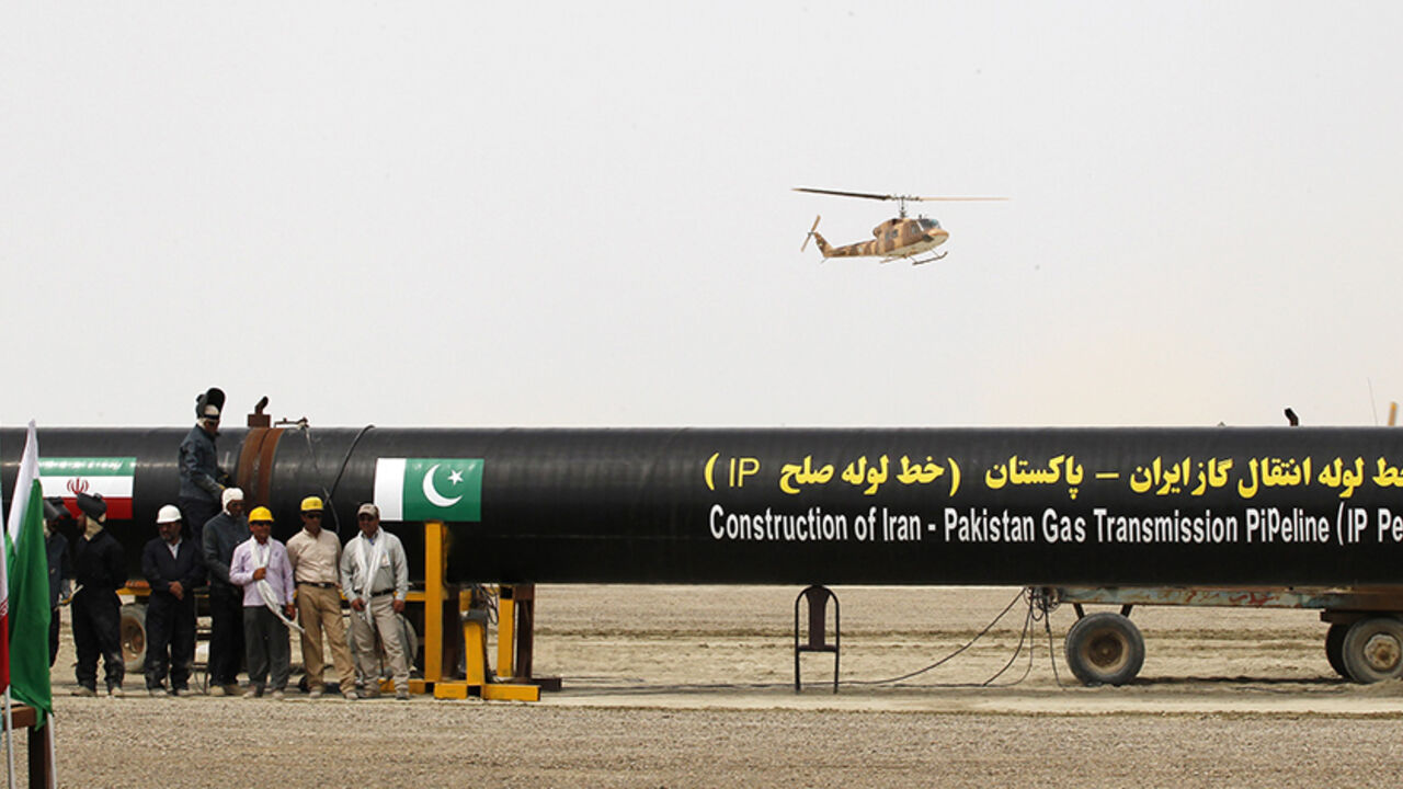 IRAN-PAKISTAN/GAS Irani workers stand near as a security helicopter lands near the pipeline during a groundbreaking ceremony to mark the inauguration of the Iran-Pakistan gas pipeline, in the city of Chahbahar in southeastern Iran March 11, 2013. Ahmadinejad and Zardari marked the start of Pakistani construction on the much-delayed gas pipeline on Monday, Iranian media reported, despite U.S. pressure on Islamabad to back out of the project. REUTERS/Mian Khursheed (IRAN - Tags: POLITICS ENERGY) - RTR3EUW9