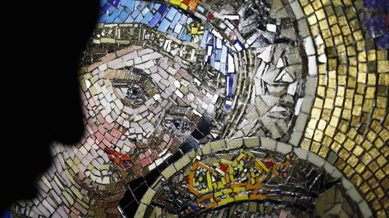 EGYPT-RELIGION/ A visitor passes an image of the Virgin Mary, as thousands of Egyptian Copts celebrate the Feast of Assumption at the Virgin Mary Church in Mostorod, east of Cairo, August 22, 2014. The Feast of Assumption marks the Virgin Mary's ascension into heaven. REUTERS/Mohamed Abd El Ghany (EGYPT - Tags: RELIGION SOCIETY) - RTR43DVG
