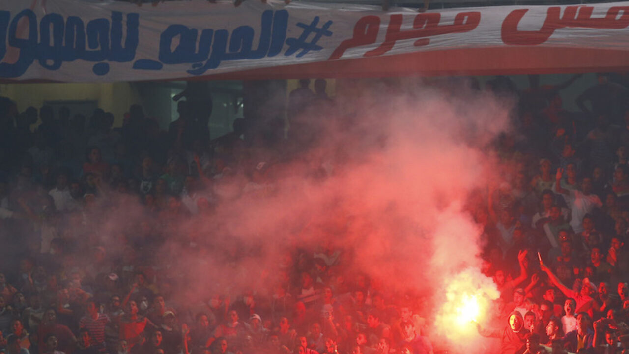 SOCCER-AFRICA/NATIONS Egyptian soccer fans known as "Ultras" shout slogans against the government and police while holding a flare during the African Nations Cup qualifying soccer match between Egypt and Botswana, in Cairo October 15, 2014. The banner reads, "Ultras not a criminal, Freedom for fans".REUTERS/Amr Abdallah Dalsh (EGYPT - Tags: SPORT SOCCER CIVIL UNREST) - RTR4ACF9