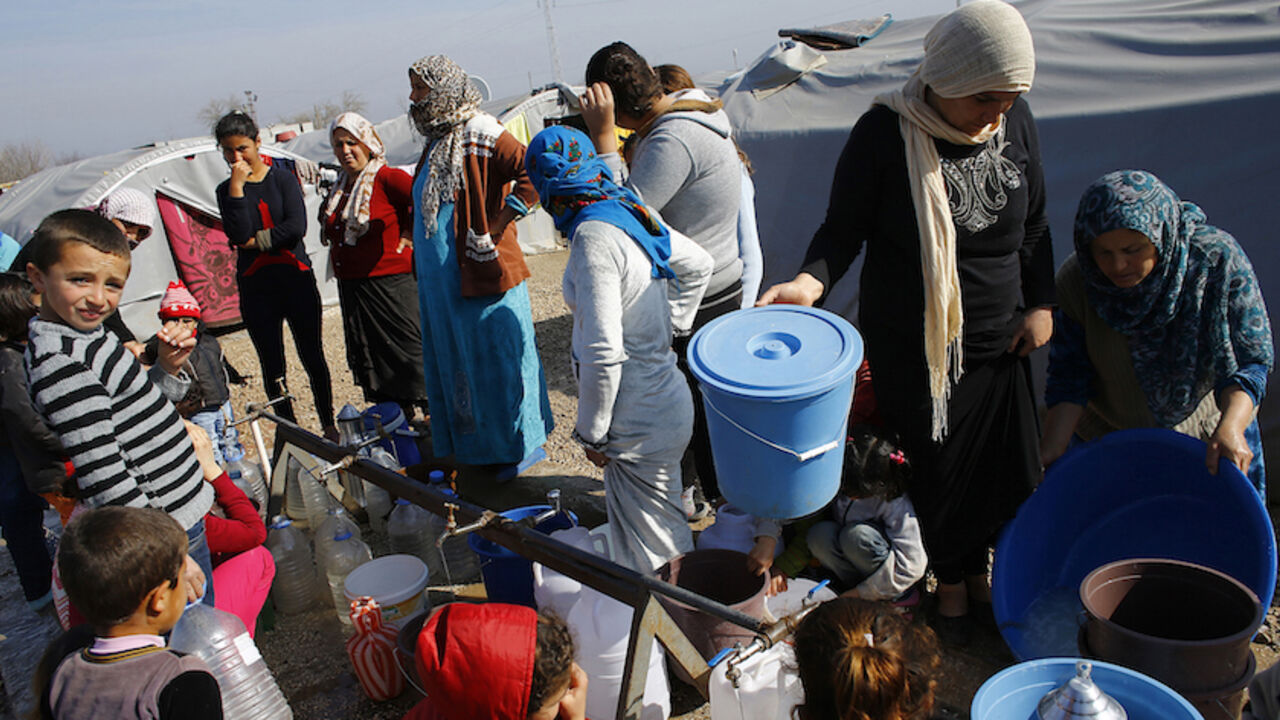 MIDEAST-CRISIS/SYRIA-KURDS Kurdish refugees from the Syrian town of Kobani wait to fill their jerrycans around a clean water source at a refugee camp in the border town of Suruc, Sanliurfa province February 1, 2015. REUTERS/Umit Bektas (TURKEY - Tags: POLITICS CIVIL UNREST CONFLICT) - RTR4NRVB