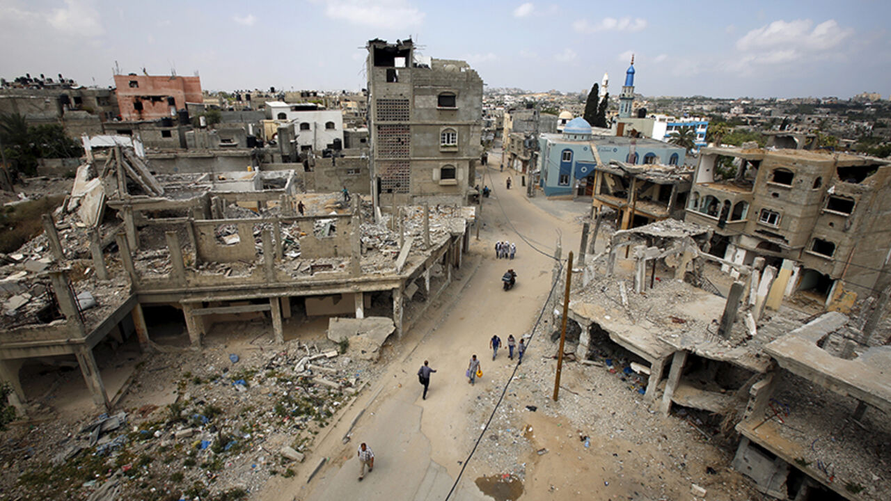 PALESTINIANS-ISRAEL/PRISONERS Palestinians walk past the ruins of houses that witnesses said were destroyed by Israeli shelling during a 50-day war last summer in Beit Hanoun in the northern Gaza Strip, where Palestinian boy al-Hassan, who was born in January 2014 after being conceived with his jailed father's sperm smuggled out of an Israeli prison, lives May 10, 2015. Hana, the Gaza wife of al-Za'an, a Palestinian prisoner in an Israeli jail, gave birth to a baby boy in January 2014 in the first successful smuggling of sperm to lead t