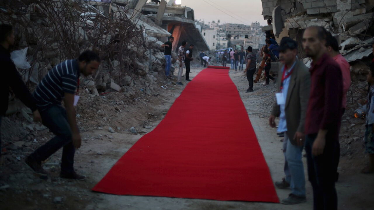 ISRAEL-PALESTINIANS/ Palestinians place a red carpet between the ruins of houses, that witnesses said were destroyed by Israeli shelling during a 50-day war last summer, before they display a film on the war in the east of Gaza City May 12, 2015. REUTERS/Mohammed Salem
- RTX1CNQ9