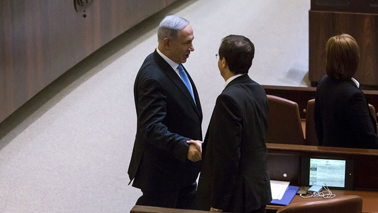 ISRAEL-POLITICS Israeli Prime Minister Benjamin Netanyahu (L) shakes hands with Isaac Herzog, co-leader of the Zionist Union party after he was sworn to office in the Knesset, the Israeli parliament, following the mid-March general elections, in Jerusalem May 14, 2015. Netanyahu's new rightist coalition government, hobbled from the outset by its razor-thin parliamentary majority, was sworn in late on Thursday amid wrangling within his Likud party over cabinet posts. REUETRS/Jim Hollander/Pool - RTX1D0Z3