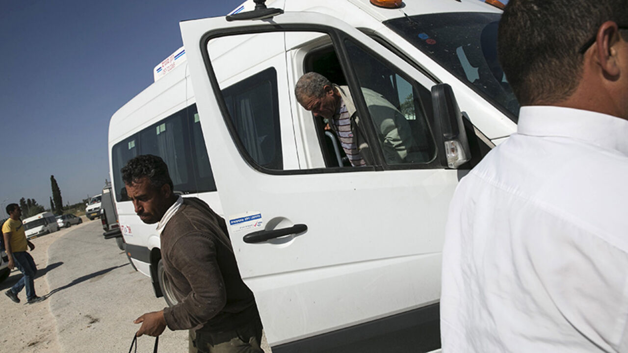 ISRAEL-PALESTINIANS/BUSES Palestinian labourers with permits to work in Israel step off a minibus as they return to the West Bank at Israel's Eyal checkpoint near the West Bank town of Qalqilya May 20, 2015. Prime Minister Benjamin Netanyahu suspended on Wednesday new bus travel and checkpoint regulations for Palestinian labourers only hours after they were imposed to an outcry by critics accusing Israel of racial segregation. REUTERS/Baz Ratner - RTX1DTRU