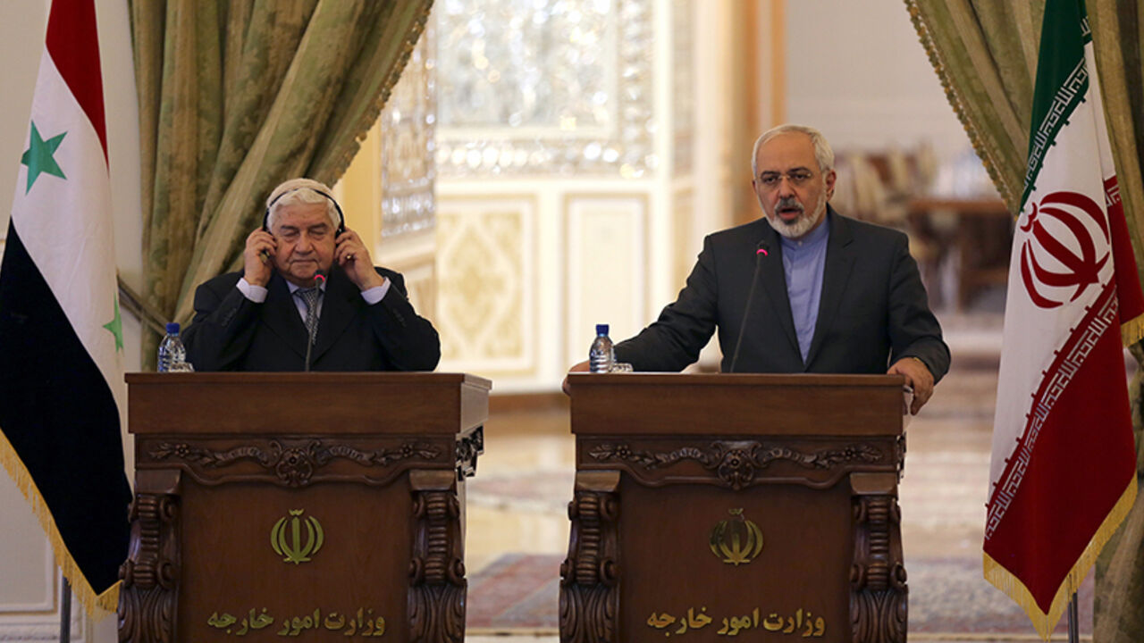 Nic6394891 Iranian Foreign Minister Mohammad Javad Zarif (R) holds a press conference with his Syrian counterpart Walid Muallem in Tehran on December 8, 2014, ahead of a conference with their Iraqi counterpart on combating extremism. Iran is the main regional ally of Syrian President Bashar al-Assad, and Tehran has acknowledged sending military advisers to assist his forces in their fight against armed rebels and jihadist militants. AFP PHOTO/ ATTA KENARE (Photo credit should read ATTA KENARE/AFP/Getty Images)