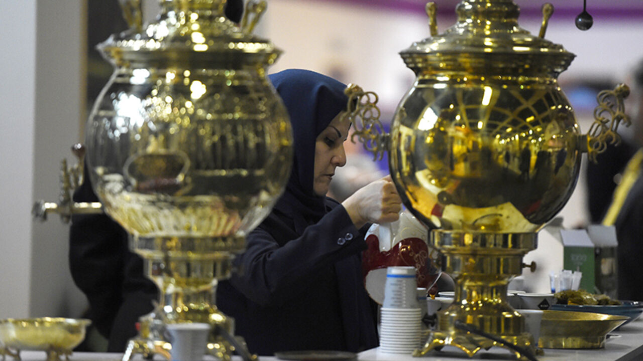 DV1981656 A woman prepares tea at a booth representing Iran at the 49th International Tourism Fair (ITB Berlin 2015) in Berlin on March 4, 2015. 10 096 exhibitors from 186 countries attend the fair that runs until March 8, 2015 in the German capital. AFP PHOTO / TOBIAS SCHWARZ (Photo credit should read TOBIAS SCHWARZ/AFP/Getty Images)