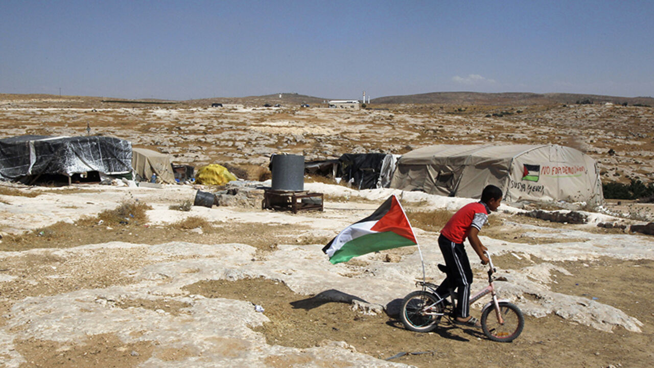 ISRAEL-PALESTINIANS/DEMOLITION A Palestinian boy rides a bicycle past tents in the West Bank village of Susiya June 24, 2012. Susiya the Israeli settlement enjoys well-watered lawns, humming electricity, and the protection of a mighty state. One rocky hill away, Susiya the Palestinian village is parched and doomed. Picture taken June 24, 2012. To match Feature ISRAEL-PALESTINIANS/DEMOLITION
REUTERS/Baz Ratner (WEST BANK - Tags: POLITICS) - RTR347HR