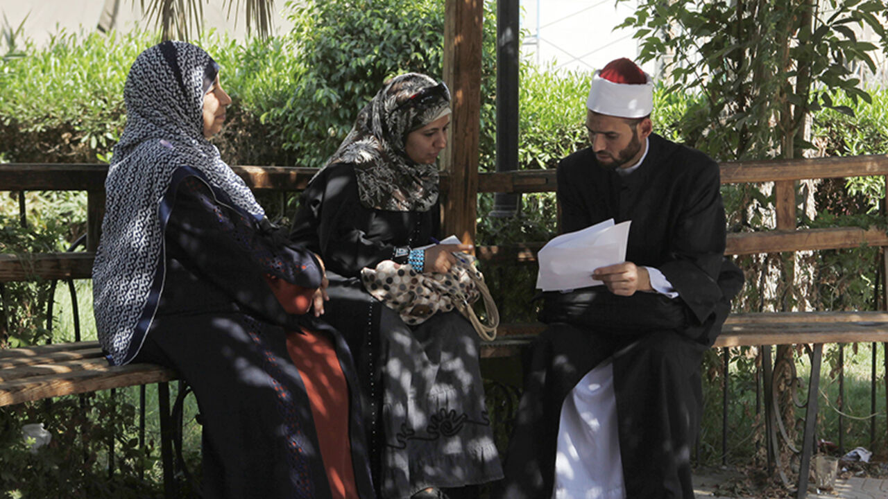 EGYPT-CONSTITUTION/ An Al-Azhar Sheikh, explains some papers in the courtyard of Al-Azhar adminstrative building, in Cairo September 10, 2012. A proposal by ultraconservative Salafis to give Egypt's main Islamic institution the final say on whether the law of the land adheres to Islamic law threatens to bring the already painfully slow process of drafting the new constitution to a grinding halt. The proposal would give the revered Al-Azhar power similar to a supreme court by making it the arbiter of whether a law conforms with