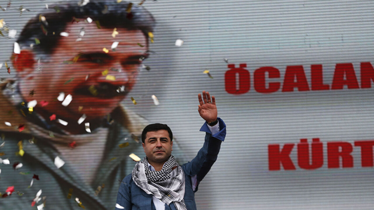 TURKEY-KURDS/ Selahattin Demirtas, co-chairman of the pro-Kurdish Peace and Democracy Party, greets his supporters during a rally to celebrate the spring festival of Newroz in Istanbul March 17, 2013. A picture of imprisoned PKK leader Abdullah Ocalan is seen in the background. REUTERS/Murad Sezer (TURKEY - Tags: POLITICS CIVIL UNREST) - RTR3F4BY