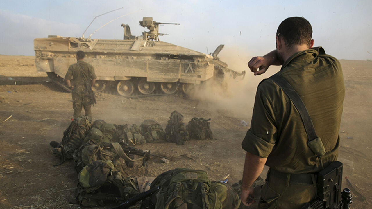 MIDEAST-GAZA/ An Israeli soldier stands at a staging area after crossing back into Israel from Gaza July 28, 2014. Israel eased its assaults in the Gaza Strip and Palestinian rocket fire from the enclave declined sharply on Monday, the military said, with both the United States and United Nations calling for a durable ceasefire. REUTERS/Baz Ratner (ISRAEL - Tags: CIVIL UNREST CONFLICT MILITARY POLITICS) - RTR40CN3