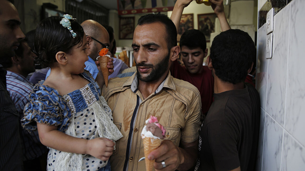 MIDEAST-GAZA/ Palestinians crowd into an ice cream shop during the first day of a three day ceasefire, in Gaza City August 5, 2014. Israel withdrew ground forces from the Gaza Strip on Tuesday and started a 72-hour ceasefire with Hamas mediated by Egypt as a first step towards negotiations on a more enduring end to the month-old war. Gaza officials say the war has killed 1,834 Palestinians, most of them civilians. Israel says 64 of its soldiers and three civilians have been killed since fighting began on July 8, after a