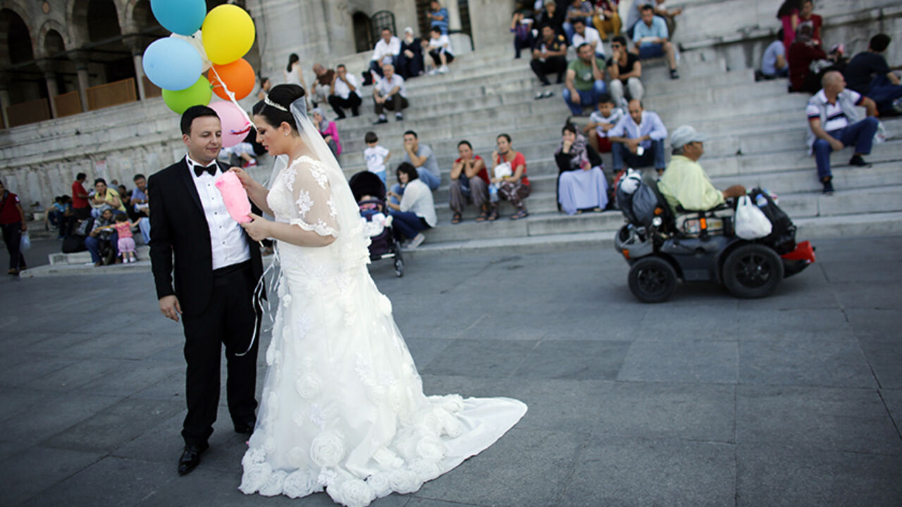 TURKEY-DAILYLIFE/ Bride Mutlu and groom Ihsan Baran pose for their photographer in front of the New mosque at Eminonu square in Istanbul September 11, 2014. REUTERS/Murad Sezer (TURKEY - Tags: SOCIETY) - RTR45W6X