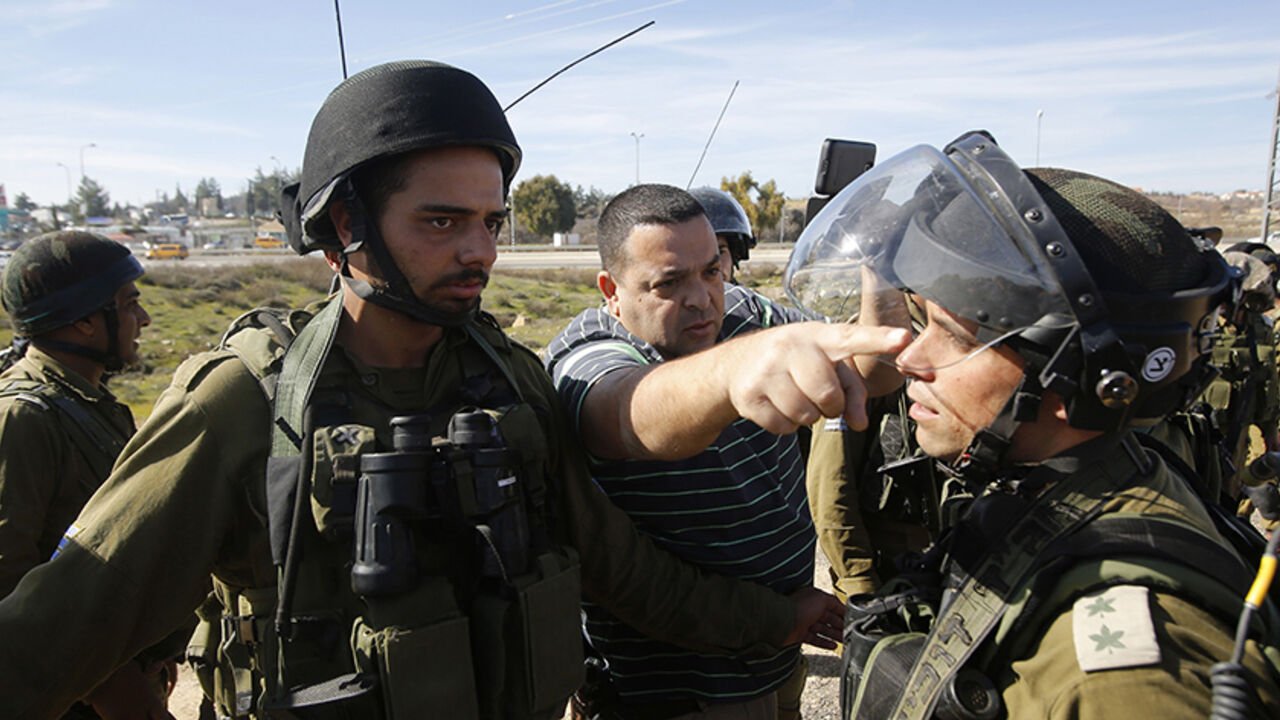 ISRAEL-PALESTINIANS/ An Israeli settler argues with Israeli soldiers during a protest organised by Palestinians against Jewish settlements near the settlement bloc of Gush Etzion in the southern West Bank city of Bethlehem January 23, 2015. REUTERS/Mussa Qawasma (WEST BANK - Tags: POLITICS CIVIL UNREST MILITARY) - RTR4MMV0