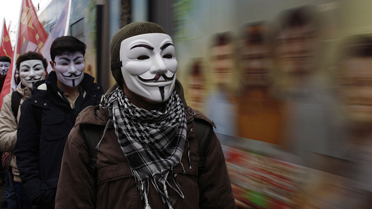 TURKEY-EDUCATION/PROTESTS High school students wearing Guy Fawkes masks take part in a protest against the education policies of the ruling AK Party as a tram drives by in Istanbul February 13, 2015. Education is the latest flashpoint between the administration of President Tayyip Erdogan, and secularist Turks who accuse him of overseeing creeping 'Islamisation' in the NATO member state. Parts of some regular schools have been requisitioned to create more places for students in "Imam Hatip" religious schools championed by Erdogan, w