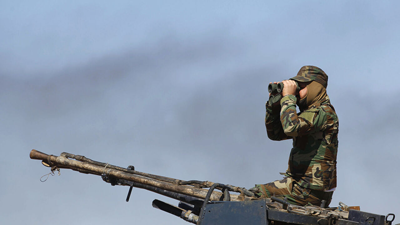 A Shi'ite fighter keeps watch in Al Hadidiya, south of Tikrit, en route to the Islamic State-controlled al-Alam town, where they are preparing to launch an offensive on Saturday, March 6, 2015. Iraqi government forces and Iran-backed militiamen entered a town on the southern outskirts of Saddam Hussein's home city Tikrit on Friday, pressing on with the biggest offensive yet against Islamic State militants that seized the north last year. REUTERS/Thaier Al-Sudani (IRAQ - Tags: POLITICS CIVIL UNREST CONFLICT 