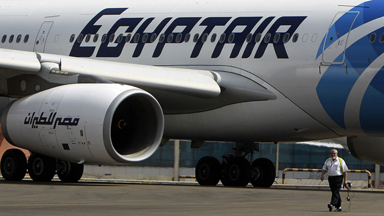 EGYPT-TOURISM/ECONOMY An airport staff walks next to an EgyptAir plane on the runway at Cairo Airport, September 5, 2013. The ongoing political crisis in Egypt has hit the once vibrant tourism industry hard, devastating a critical part of the country's economy. And with visitors scared away by civil strife in the aftermath of the ouster of President Mohamed Mursi, Egypt's national airliner, EgyptAir has been hit hard by the tourism slowdown. The airline has taken the brunt of losses in the tourism sector, losing billions of poun