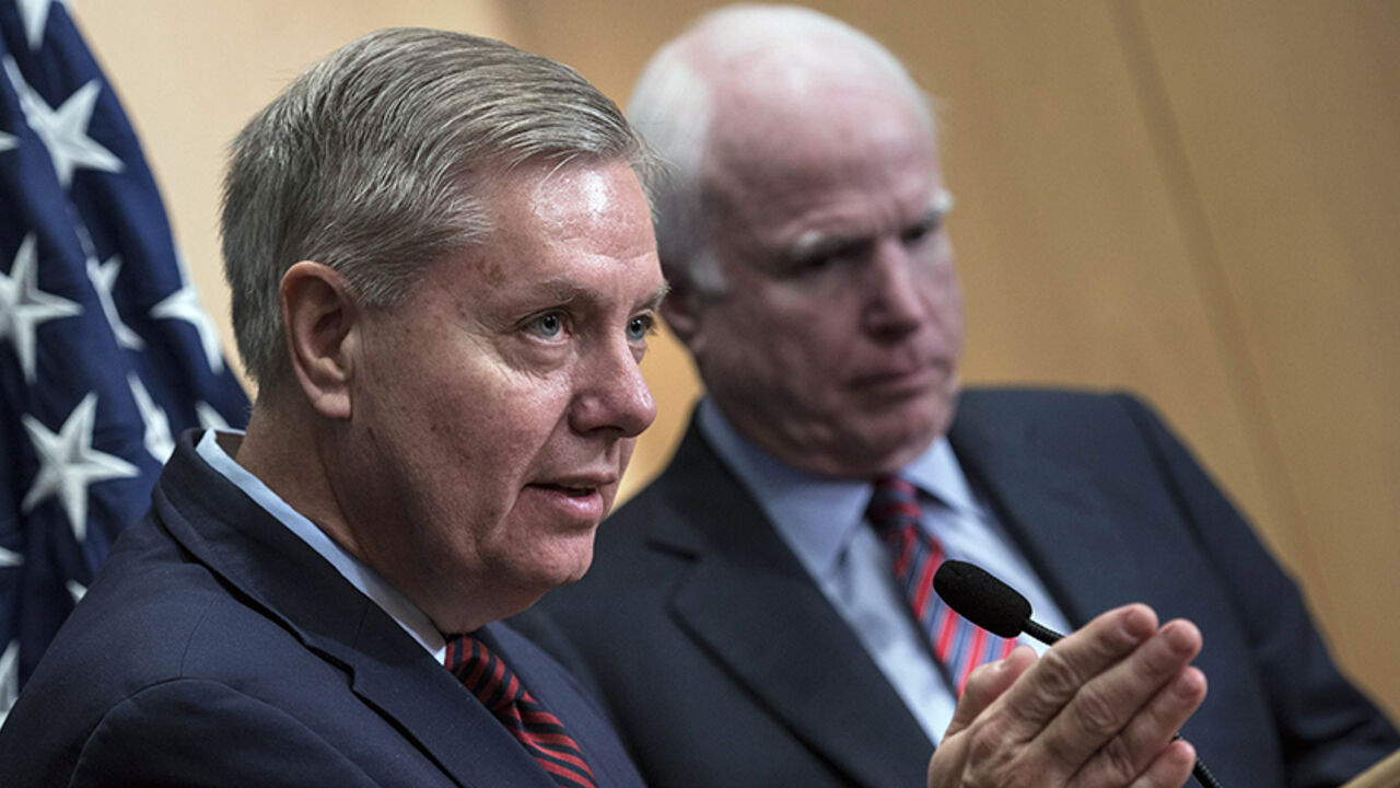 ISRAEL-PALESTINIANS/KERRY U.S. Senator Lindsey Graham (L) speaks near U.S. Republican Senator John McCain during a news conference at the David Citadel hotel in Jerusalem January 3, 2014. REUTERS/Brendan Smialowski/Pool (JERUSALEM - Tags: POLITICS) - RTX170Z3