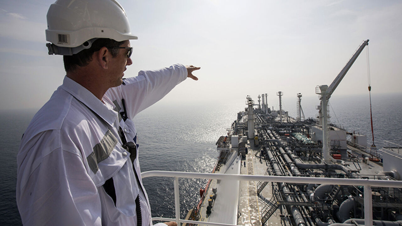 ISRAEL-NATGAS/TANKER An officer points as he stands on a tanker carrying liquefied natural gas in the Mediterranean, some 10 km (6 miles) from the coastal Israeli city of Hadera January 22, 2014. Permanently anchored in the choppy waters of the eastern Mediterranean, the tanker Excellence is in a constant state of alert, waiting for the emergency phone call that Israel needs fuel. The gas, imported and stored in liquid form on the tanker, can be "regassified" and pumped through a special buoy into an underwater pipeline, provid