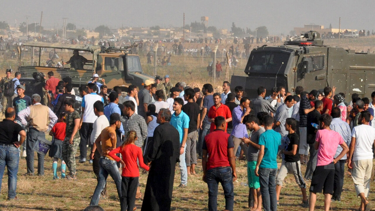 MIDEAST-CRISIS/TURKEY-REFUGEES Syrian refugees from Tel Abyad wait on the Turkish-Syrian border after crossing into Turkey near the Akcakale border gate in Sanliurfa province, Turkey, June 14, 2015. Kurdish-led militia backed by U.S.-led air strikes fought Islamic State near a Syrian town at the Turkish border on Sunday, a monitoring group and a Kurdish official said, in an advance that has worried Turkey. Concerned about an expansion of Kurdish sway in Syria, Turkish President Tayyip Erdogan said Kurdish groups were taking over areas ev