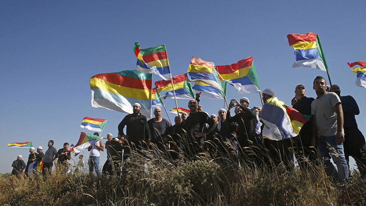 SYRIA-CRISIS/ISRAEL-DRUZE Members of the Druze community watch the fighting in the Druze village of Khadr in Syria, as they stand on the Israeli side of the border fence between Syria and the Israeli-occupied Golan Heights, near Majdal Shams, June 16, 2015. Israel's president expressed his concern to the United States last week about the fate of the Druze minority in Syria, saying around 500,000 of them were under threat from Islamist militants in an area near the Israeli border. REUTERS/Baz Ratner - RTX1GRM4