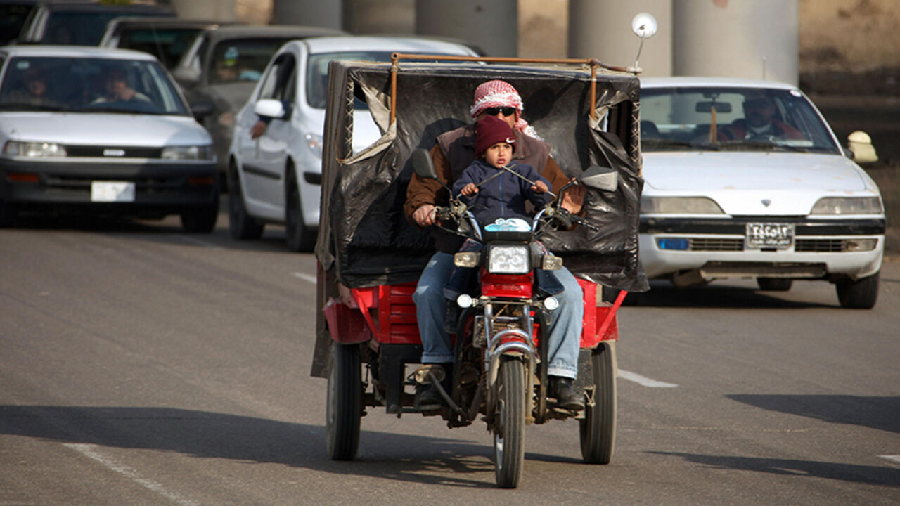Nic238413 An Iraqi man and a child ride a small motorcycle through the streets of Baghdad on February 20, 2008. Moqtada al-Sadr's six-month freeze on attacks by his Mahdi Army has strengthened his hand and allowed him to purge dissidents from the ranks of the militia, analysts and aides of the Shiite cleric said. Sadr, long a thorn in the side of US-led forces in Iraq, is expected to announce on February 22, 2008 whether he will renew his unilateral ceasefire, set to expire the day after. AFP PHOTO/PATRICK BAZ (Photo
