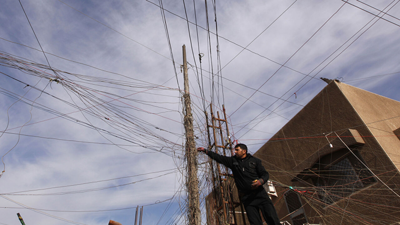 IRAQ-WITHDRAWAL/OIL An electrician uses an Avometer to check wires connected to his local generator on a street in Baghdad, December 13, 2011. Iraq's financial system is slowly embracing the free market after years of tight control under Saddam; a fledging stock market is attracting foreign money while the banking and telecommunications industries are growing rapidly. But the national grid provides only a few hours of intermittent power a day, forcing Iraqis to live off noisy diesel-fueled generators. Picture taken December 13