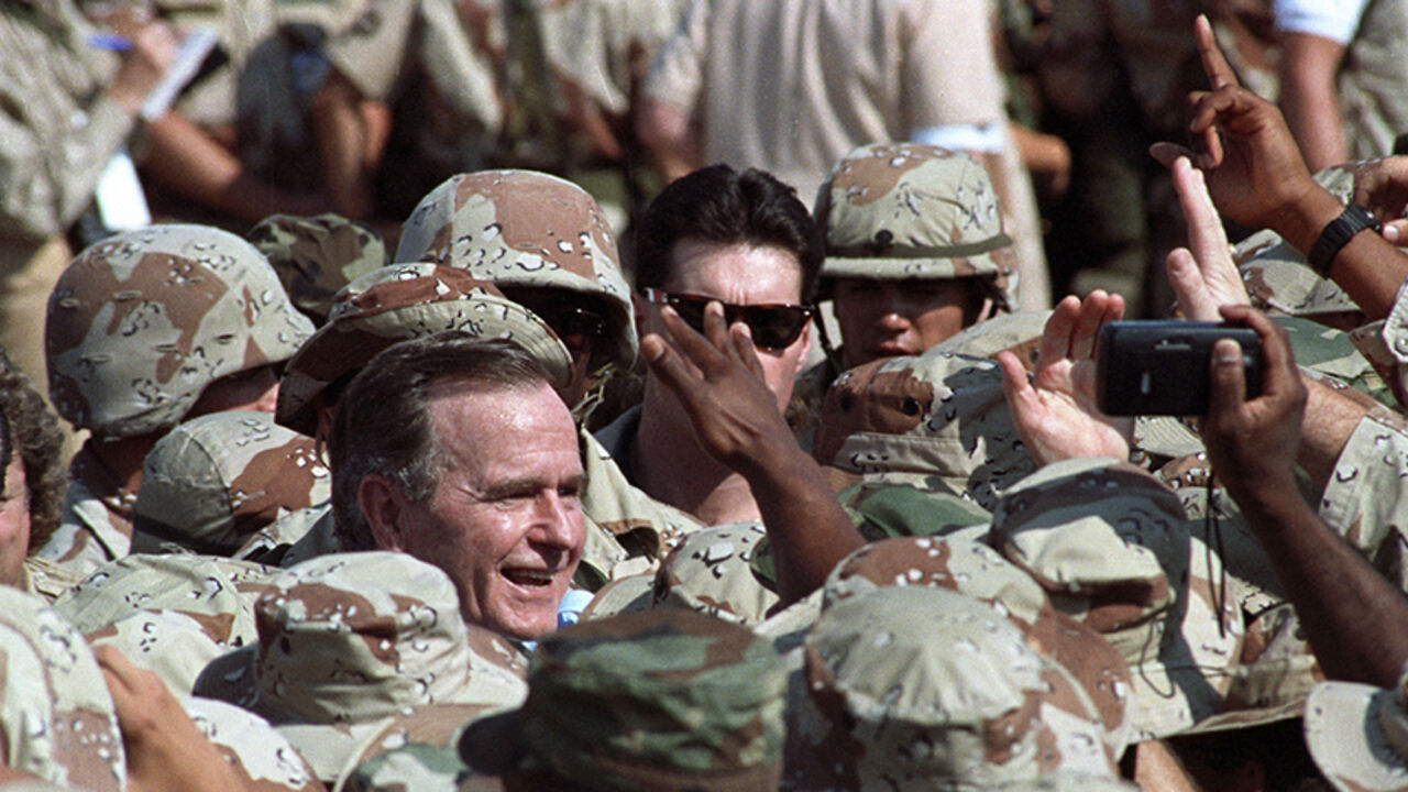 SAUDI ARABIA President George H.W. Bush is surrounded by a sea of U.S. military personnel as he greets troops following an arrival ceremony in the eastern Saudi Arabian city of Dhahran November 22, 1990. Bush celebrates Thanksgiving Day with U.S. troops from all branches of the military deployed here after the Iraqi invasion of Kuwait. Reuters/Terry Bochatey ( SAUDI ARABIA - Tags: POLITICS CIVIL UNREST) BEST QUALITY AVAILABLE - RTR2ZNUI