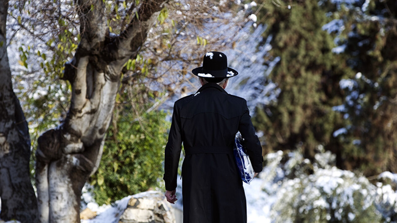 ISRAEL-SNOW/ An Ultra-Orthodox Jewish man walks on a snow-covered street near Jerusalem's Old City January 10, 2015. REUTERS/Ronen Zvulun (JERUSALEM - Tags: ENVIRONMENT RELIGION TPX IMAGES OF THE DAY) - RTR4KTNO