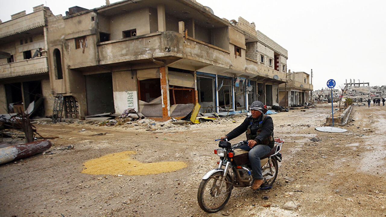 MIDEAST-CRISIS/SYRIA-KOBANI A fighter of the Kurdish People's Protection Units (YPG) patrols on a motorcycle in the streets of the northern Syrian town of Kobani January 30, 2015. Sheets meant to hide residents from snipers' sights still hang over streets in the Syrian border town of Kobani, and its shattered buildings and cratered roads suggest those who fled are unlikely to return soon. Kurdish forces said this week they had taken full control of Kobani, a mainly Kurdish town near the Turkish border, after months of bombardment by I