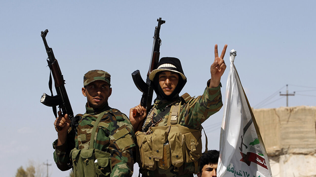 MIDEAST-CRISIS/IRAQ Sunni fighters who have joined Shi'ite militia groups known collectively as Hashid Shaabi (Popular Mobilization), who are allied with Iraqi forces against the Islamic State, gesture with their weapons in al-Alam Salahuddin province March 17, 2015. Iraq paused its Tikrit offensive on Monday and officials called for more air strikes against Islamic State militants, while an officer said Kurdish forces sustained two more chlorine gas attacks by insurgents. REUTERS/Thaier Al-Sudani (IRAQ - Tags: POLITICS CIVIL