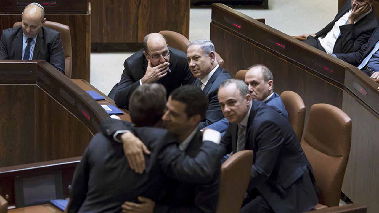ISRAEL-POLITICS/ Israeli Prime Minister Benjamin Netanyahu (C) sits next to his Defense Minister Moshe Ya'alon (L) during a swearing-in ceremony at the Knesset, the Israeli parliament, in Jerusalem May 14, 2015. Netanyahu's new rightist coalition government, hobbled from the outset by its razor-thin parliamentary majority, was sworn in late on Thursday amid wrangling within his Likud party over cabinet posts. Picture taken May 14, 2015. REUETRS/Jim Hollander/Pool - RTX1D2SJ