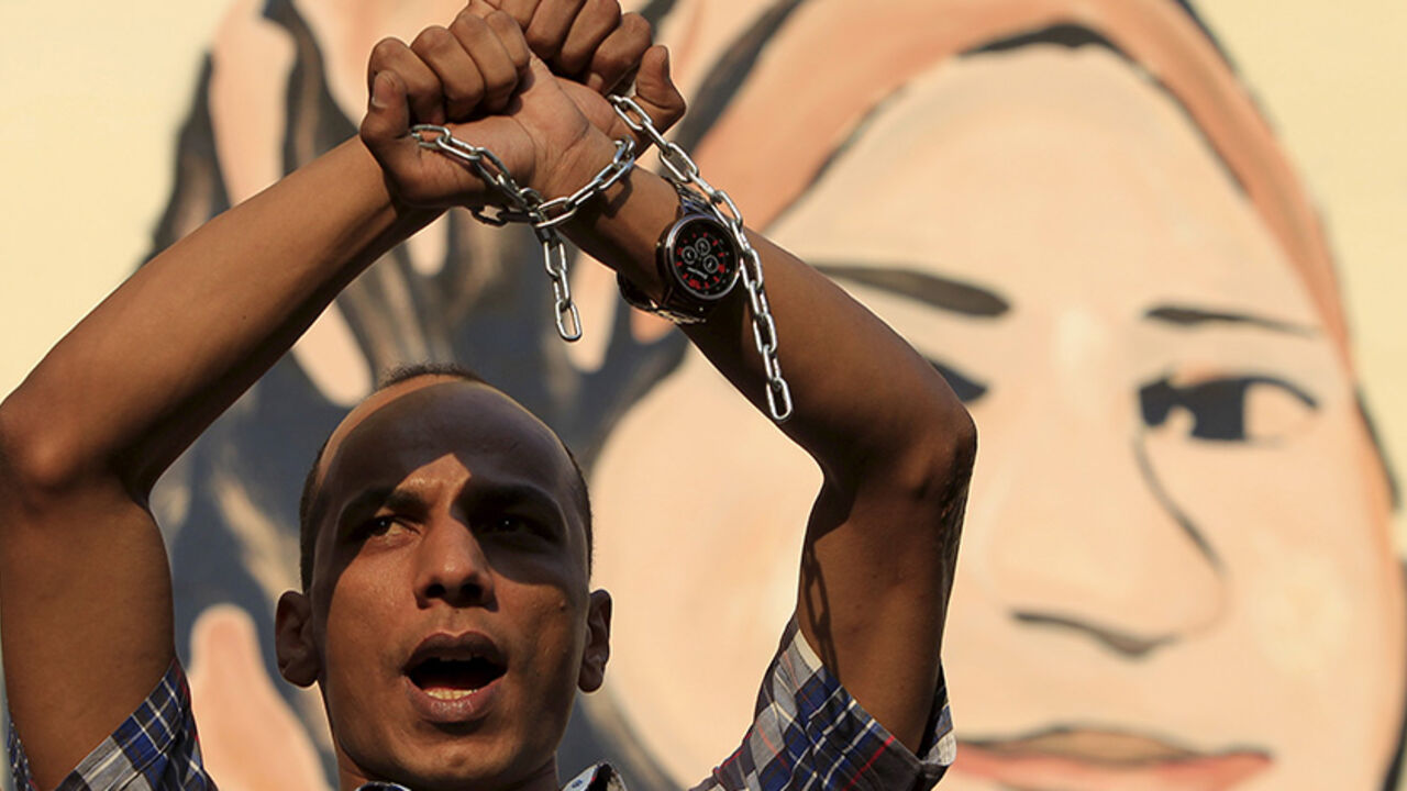 EGYPT-CRACKDOWN/ A protester holds up his hands, which are chained together, as journalists and members of the April 6 movement protest against the restriction of press freedom and demand the release of detained journalists in front of the Press Syndicate in Cairo June 10, 2015. Egyptian security forces have arrested dozens of activists ahead of a general strike planned for Thursday, activists and security sources say, part of what the activists describe as an unrelenting crackdown on dissent. REUTERS/Mohamed Abd El Ghany -