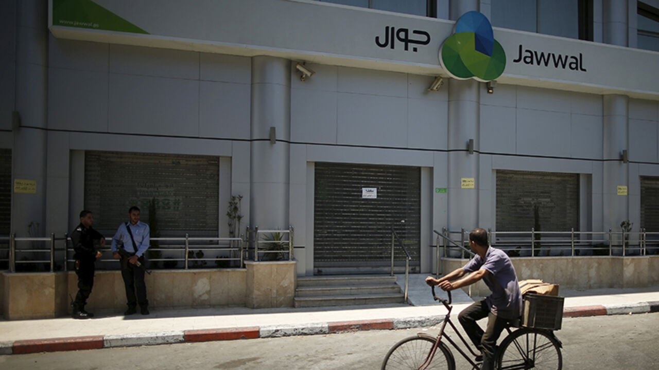 PALESTINIANS-GAZA/CELLULAR Palestinian policemen loyal to Hamas stand guard outside closed Jawwal company headquarters in Gaza City June 30, 2015. The Hamas-appointed attorney general in Gaza shut down the offices of the territory's only mobile-phone provider on Tuesday, saying the company, Jawwal, had not paid its taxes. Jawwal is a subsidiary of the Palestine Telecommunications Co. (PalTel), the largest listed company in the Palestinian territories. It is the sole provider of mobile phone services in Gaza, with around 1.3 million c