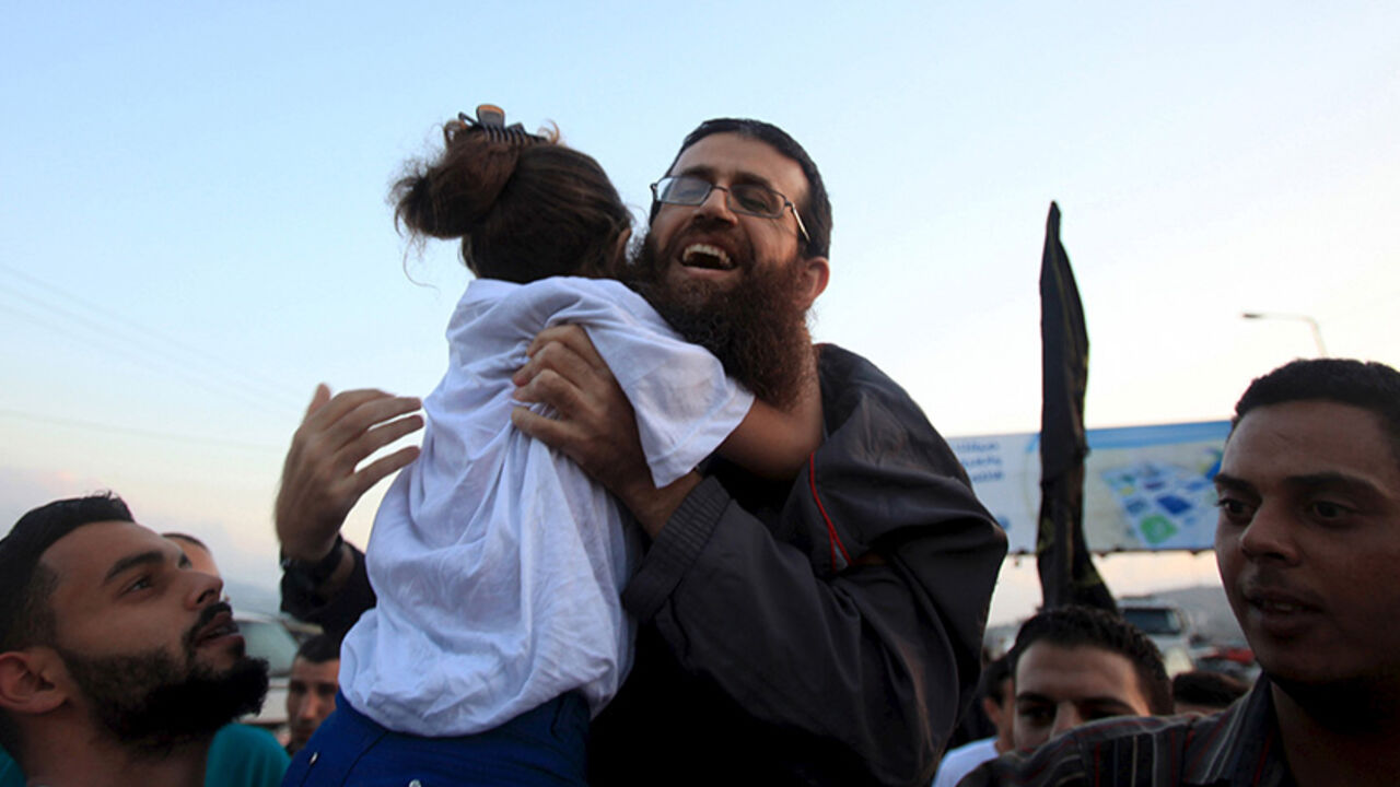 ISRAEL-PALESTINIANS/ Islamic Jihad leader, Khader Adnan is hugged by his daughter upon his release from an Israeli jail, in the West Bank village of Arabeh near Jenin July 12, 2015. Israel on Sunday released Adnan from jail following a deal last month in which he agreed to end a 56-day hunger strike, Islamic Jihad sources in the West Bank said. REUTERS/Stringer TPX IMAGES OF THE DAY - RTX1K24O