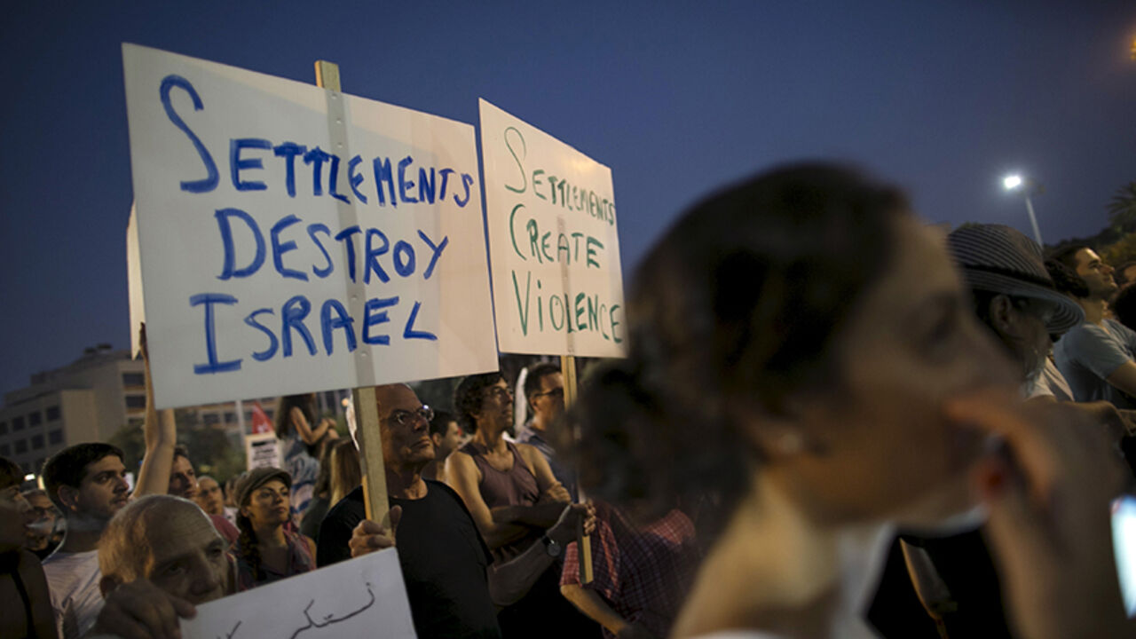ISRAEL-PALESTINIANS/ Left-wing protesters write slogans on signs before a protest condemning Friday's arson attack in the West Bank, at Rabin square in Tel Aviv August 1, 2015. Some 3,000 demonstrators gathered for the rally organised by the Israeli anti-settler group Peace Now against the attack by suspected Jewish assailants who torched a Palestinian home in the occupied West Bank on Friday, killing an 18-month-old toddler and seriously injuring three other family members, an act that Israel's prime minister described as terr