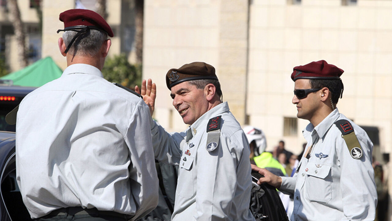 ISRAEL/ Outgoing Lieutenant-General Gabi Ashkenazi (C) waves to soldiers as he leaves after a handover ceremony in which he was replaced by the new Chief of Staff Lieutenant-General Benny Gantz (L) at the Kirya base in Tel Aviv February 14, 2011. REUTERS/Baz Ratner (ISRAEL - Tags: POLITICS MILITARY) - RTR2IL8L
