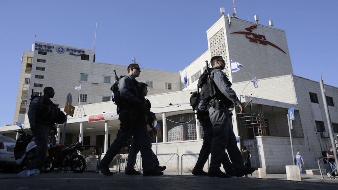PALESTINIAN-ISRAEL/SEMINARY Israeli police officers walk past a post office building in East Jerusalem April 29, 2014. A Jewish seminary, in a bustling commercial area in the same building as a post office serving thousands of Palestinians every day, is the first Jewish housing venture on Saladin Street, a main shopping thoroughfare across from the walled Old City. Palestinians and Israeli critics worry the placement of the academy in such a central location is asking for trouble in East Jerusalem, which has stayed largely trouble-fre