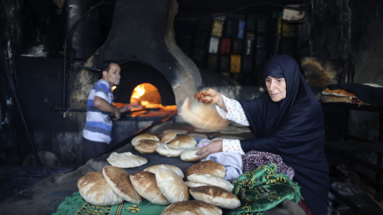 MIDEAST-GAZA/ A Palestinian bakes bread in a clay oven in Khan Younis in the southern Gaza Strip July 27, 2014. Fighting subsided in Gaza on Sunday after Hamas Islamist militants said they backed a 24-hour humanitarian truce, but there was no sign of any comprehensive deal to end their conflict with Israel. REUTERS/Ibraheem Abu Mustafa (GAZA - Tags: SOCIETY) - RTR40AIF