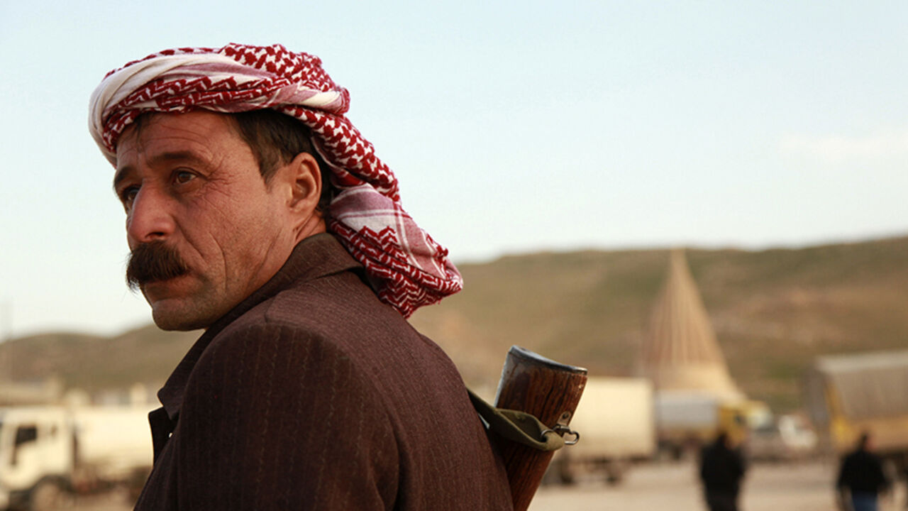 MIDEAST-CRISIS/IRAQ-SINJAR A man from the minority Yazidi sect stands guard at Mount Sinjar, in the town of Sinjar, December 20, 2014. Iraqi Kurdish fighters flashed victory signs as they swept across the northern side of Sinjar mountain on Saturday, two days after breaking through to free hundreds of Yazidis trapped there for months by Islamic State fighters. REUTERS/Ari Jalal (IRAQ - Tags: POLITICS CIVIL UNREST MILITARY) - RTR4IV2I