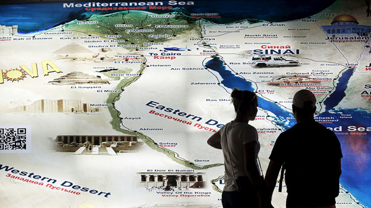 EGYPT-TOURISM/ A tourist couple looks at a map of Egypt at the Red Sea resort of Sharm el-Sheikh city, which is hosting the Arab Summit on Saturday, in the South Sinai governorate, south of Cairo March 27, 2015. REUTERS/Amr Abdallah Dalsh - RTR4V7TI