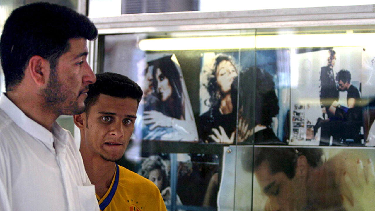 IRAQ PORN Iraqi men walk past posters advertising a pornographic film at a cinema
in Baghdad, April 30, 2003. Pornography and prostitution was officially
banned under the regime of Saddam Hussein until his ousting from power
by U.S.-led forces two weeks ago.
REUTERS/Zohra Bensemra - RTRMOD7
