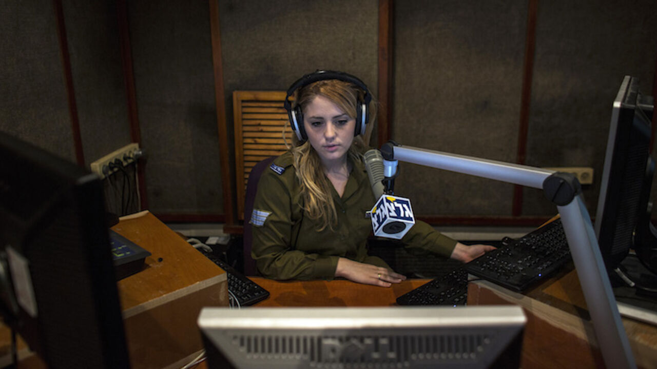 ISRAEL/ An Israeli soldier from Galei Tzahal, the Israeli army radio station, speaks during a broadcast session at the station's studio in Jaffa, south of central Tel Aviv November 10, 2013. The Israeli military operates two radio stations, a news-based station that started broadcasting in 1950, and Galgalatz, a popular music station marking its 20th anniversary. The stations mostly employ soldiers who work alongside civilian presenters, including leading names in Israeli broadcasting. Picture taken November 10, 20