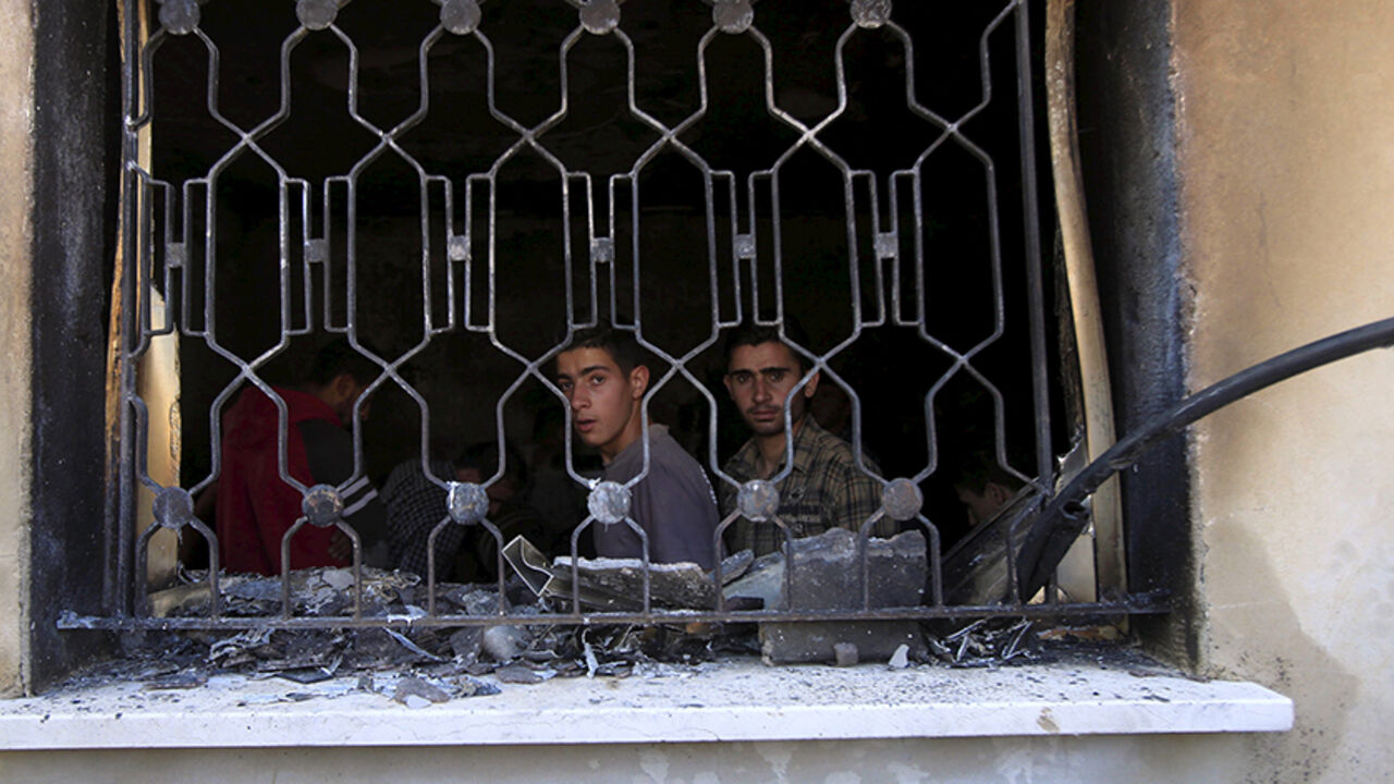 ISRAEL-PALESTINIANS/ Palestinians look out of a house that had been torched in a suspected attack by Jewish extremists, killing an 18-month-old Palestinian child, injuring a four-year-old brother and both their parents at Kafr Duma village near the West Bank city of Nablus July 31, 2015. The house fire in the occupied West Bank suspected to have been set by Jewish extremists on Friday, Israeli security officials said. A neighbouring house was also badly damaged but it had been empty and there were no casualties there. The three