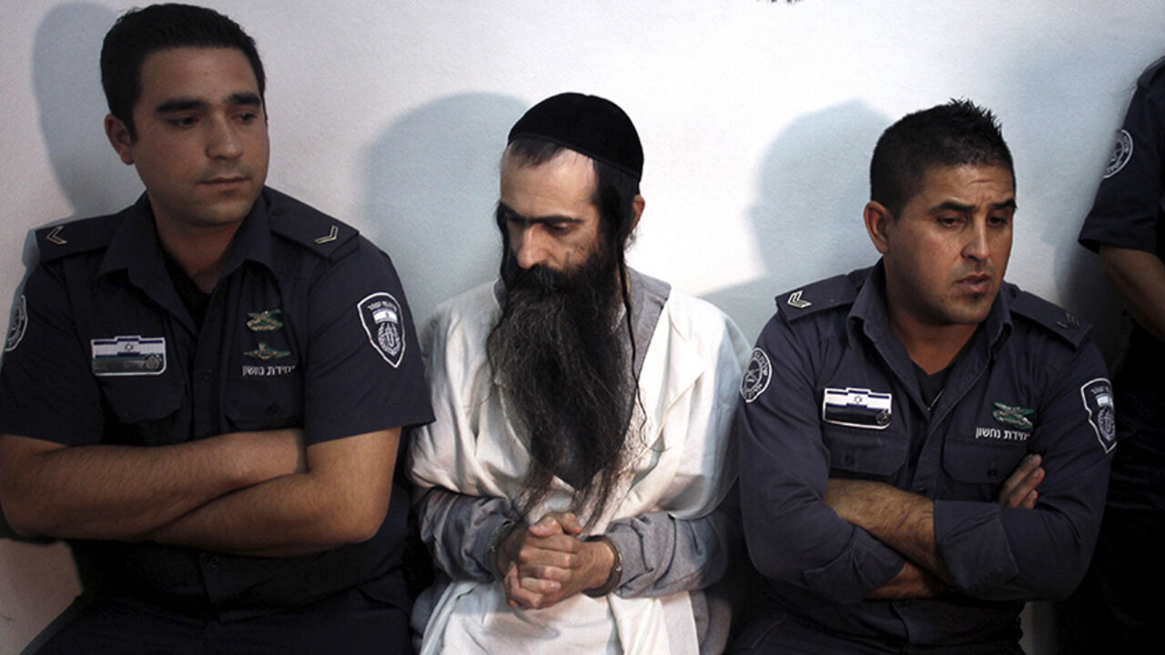 ISRAEL-GAY/ Yishai Schlissel (C) is escorted by security personnel at the Jerusalem Magistrates Court July 31, 2015. Schlissel is suspected of stabbing and wounding six participants at a Gay Pride parade in Jerusalem on Thursday. REUTERS/Muammar Awad - RTX1MITX