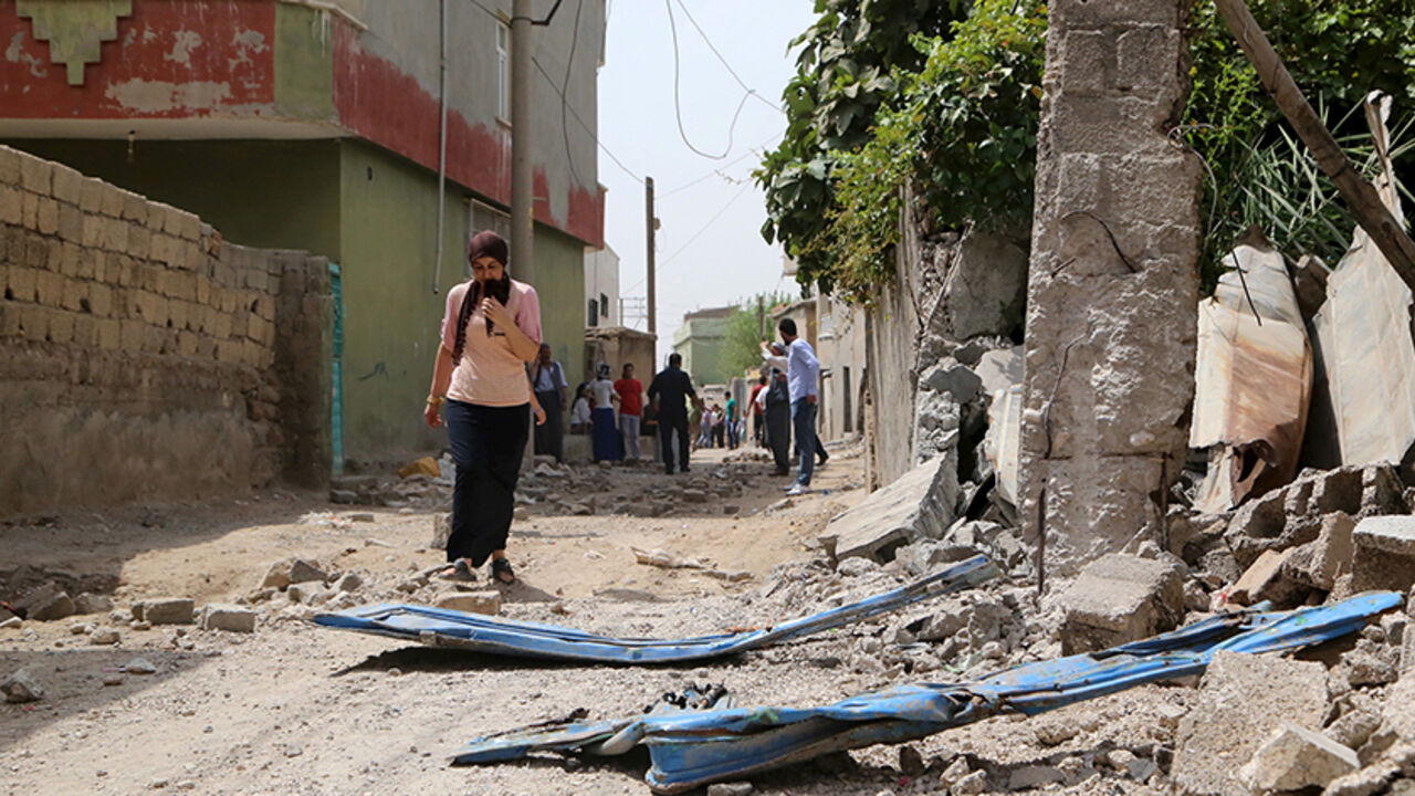 MIDEAST-CRISIS/TURKEY-KURDS A woman walks along a street in the southeastern Turkish town of Silopi in Sirnak province, near the Turkish-Iraqi border crossing of Habur, Turkey, August 7, 2015. Five people were killed in eastern Turkey on Friday in a series of clashes between security forces and Kurdish militants, part of a surge in violence that has put further strain on a fragile peace process between Ankara and the rebels. Three people were killed and seven wounded during clashes between police and militants of the Kurdistan Workers