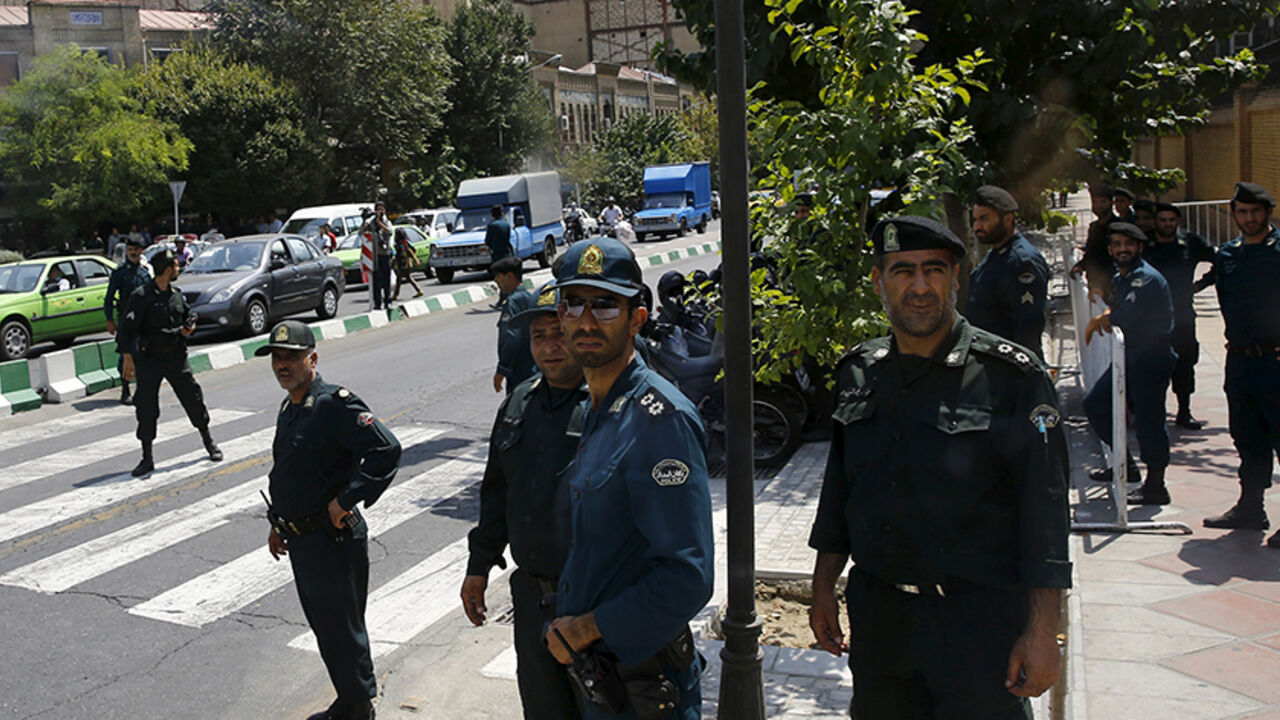 IRAN-NUCLEAR/BRITAIN Police officers watch as a convoy carrying members of the British media leaves the British Embassy in Tehran, Iran August 23, 2015. Britain reopened its embassy in Tehran on Sunday, nearly four years after protesters ransacked the ambassador's residence and burned the Union Jack. In a signal of the most striking thaw in Western ties with Iran for over a decade, Foreign Secretary Philip Hammond watched the British flag being raised in the garden of the opulent 19th century building while the national anthem