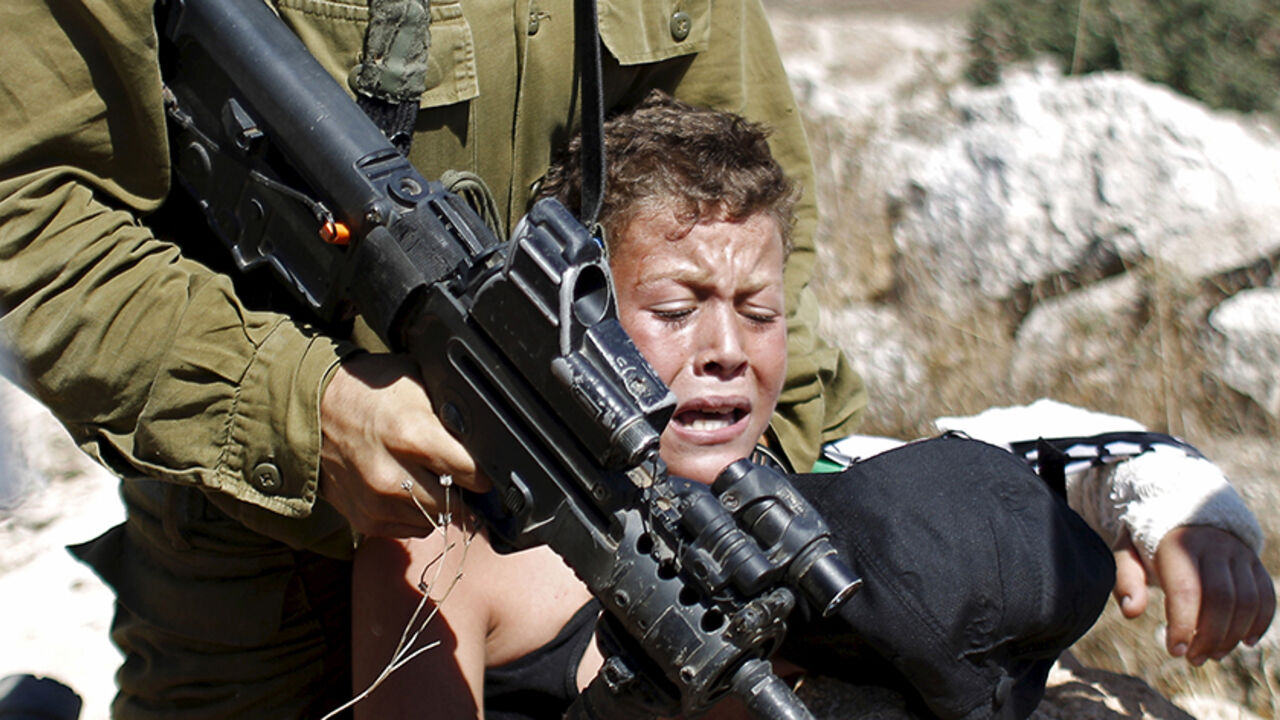ISRAEL-PALESTINIANS/ An Israeli soldier detains a Palestinian boy during a protest against Jewish settlements in the West Bank village of Nabi Saleh, near Ramallah August 28, 2015. REUTERS/Mohamad Torokman - RTX1Q2I3