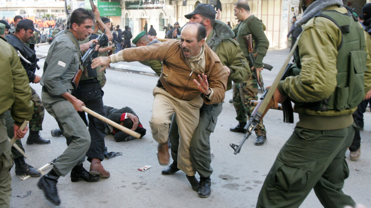 PALESTINIANS-ISRAEL/DEATH Members of the Palestinian security forces scuffle with protesters during an anti-Annapolis rally in the West Bank city of Hebron November 27, 2007. A Palestinian demonstrator was killed on Tuesday during a West Bank protest against the Annapolis peace conference that drew fire from Palestinian security forces, local medics said. Medical workers said the 35-year-old killed in Hebron had been shot in the chest and that 15 other protesters were injured during clashes with security forces loyal to President Ma
